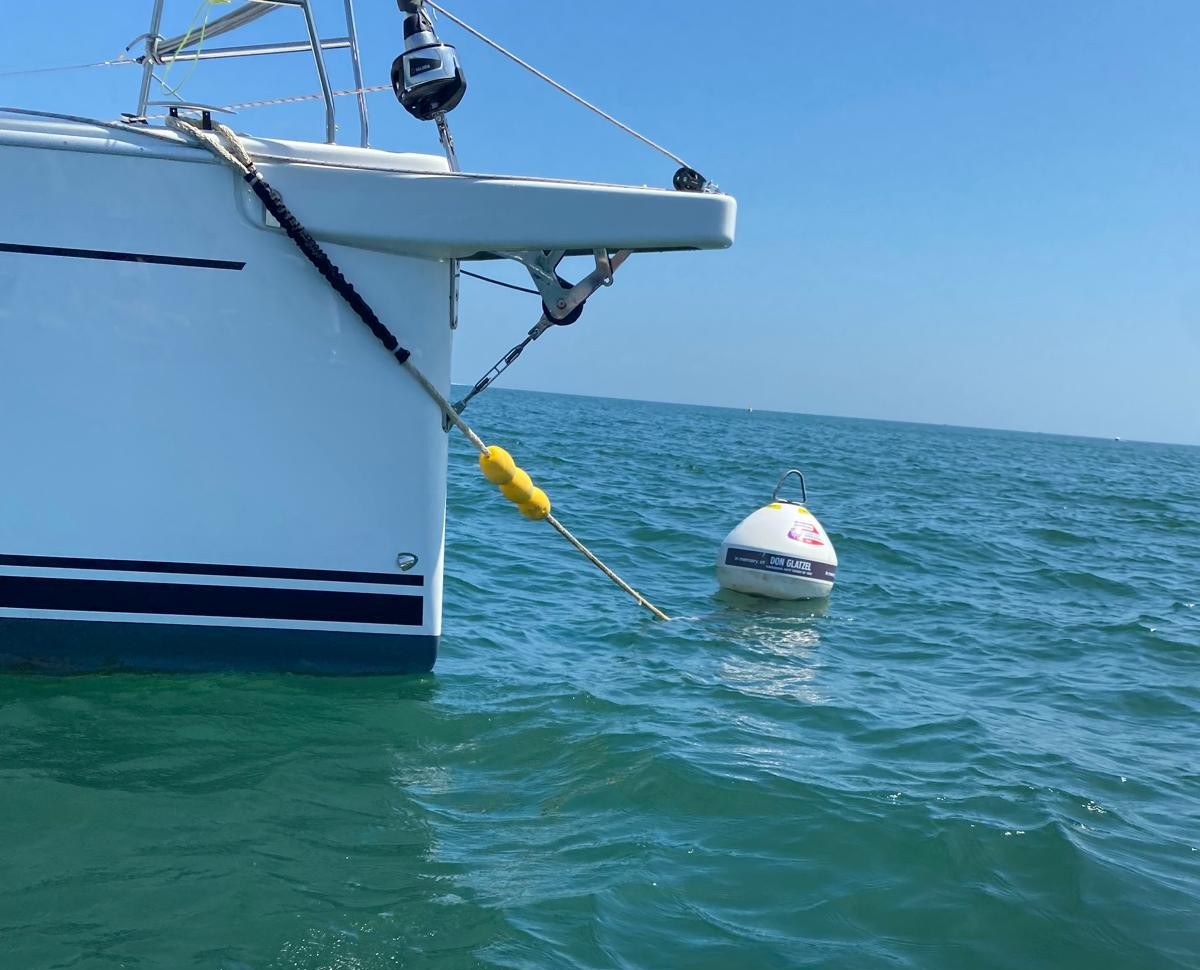 Front end of a white boat tied to an eco-mooring.