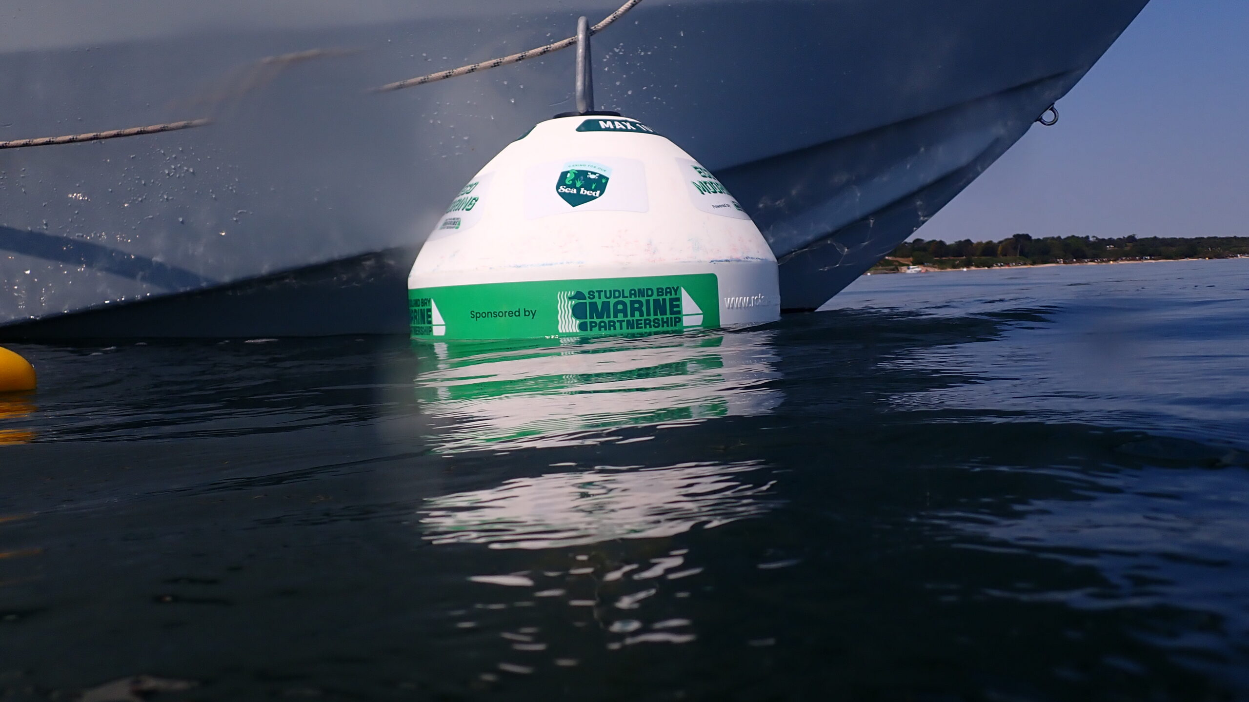 Eco-mooring buoy with the hull of a boat behind it.